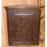 A Victorian carved oak hanging corner cupboard, W.102cm