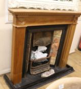 A tiled fire place and fire surround, W.137cm