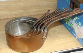 A set of five graduated copper saucepans