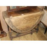 A 1920's carved oak gateleg table, W.104cm