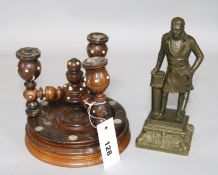 A treen candlestand and a statue of a gentleman