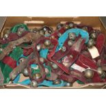 A collection of chromatic crotal, rumbler and harness bells, some plated, most fixed to velvet-