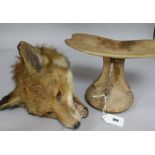 A taxidermic fox's head and a tribal head stand