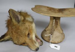 A taxidermic fox's head and a tribal head stand