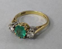 A late 1970's 18ct gold, three stone emerald and diamond ring, size L.