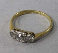 An early 20th century 18ct gold and platinum three stone diamond ring, size N.