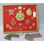 A collection of British military badges and a pair of shoulder epaulettes