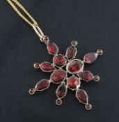 A Victorian gold and garnet set star pendant, with closed back setting, on a later fine link