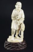 A Japanese ivory figure of a farmer holding his pipe, signed Gyozan, early 20th century, standing
