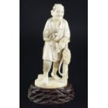 A Japanese ivory figure of a farmer holding his pipe, signed Gyozan, early 20th century, standing