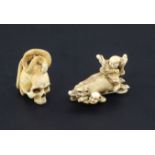 Two Japanese ivory netsuke, Meiji period, the first carved as two huntsmen battling with a boar, two