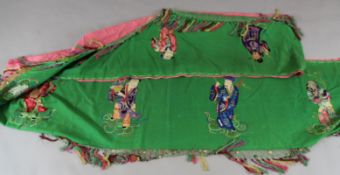 A Chinese green fabric banner panel, early 20th century, embroidered in silk with eight figures of