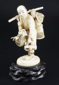A Japanese ivory okimono of a basket seller, early 20th century, some of the hats inlaid with