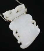 A Chinese archaistic white jade pendant, 19th / 20th century, with white metal mount and chain (26cm