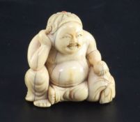 A Japanese ivory seated figure of Hotei, 18th / 19th century, with braided hair inset with coral,