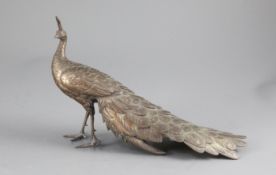 A Japanese silvered copper-bronze figure of a peacock, Meiji period, standing with its tail feathers