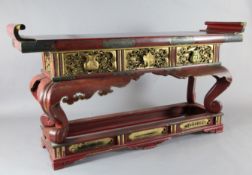 A Japanese red and gilt lacquer altar table, late 19th century, with scroll end top above engraved