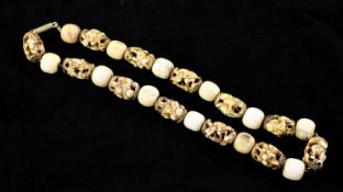 A Japanese ivory and bone Ojime bead necklace, late 19th century, composed of 12 eliptical ivory