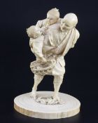 A Japanese ivory group of a man carrying two boys, Meiji period, one boy holding a basket of