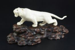 A Japanese ivory figure of a prowling tiger, signed Gyoku..? Meiji period, with glass inset eyes,