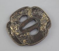 A Japanese parcel gilt bronze tsuba, 19th century, cast in relief to each side with shi-shi amid