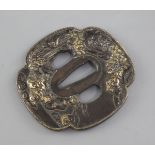 A Japanese parcel gilt bronze tsuba, 19th century, cast in relief to each side with shi-shi amid