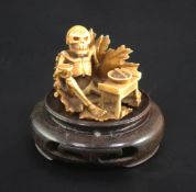A Japanese ivory netsuke of a skeleton, early 20th century, signed Sei..? seated on a lotus leaf and