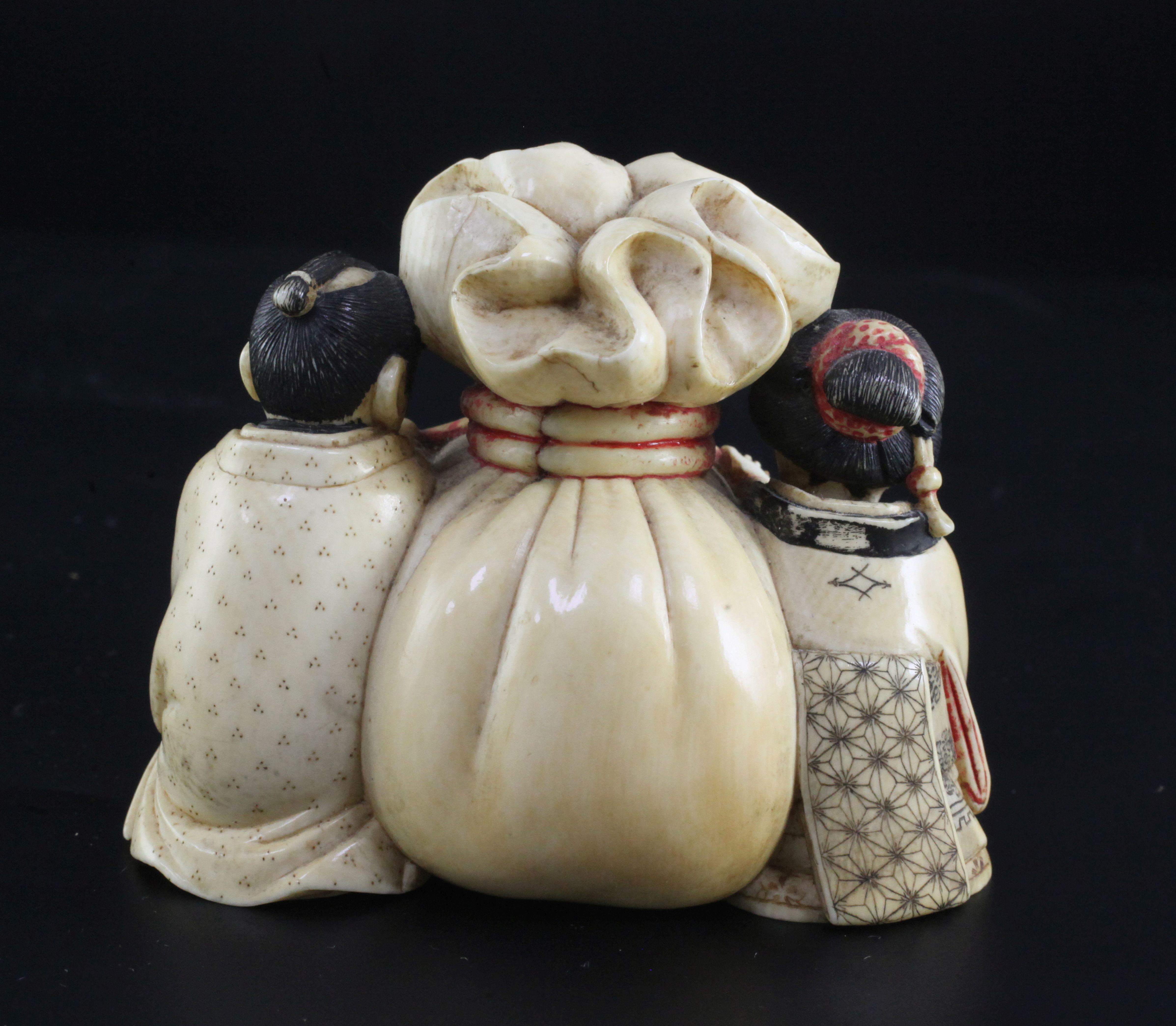 A Japanese ivory okimono of a man and woman holding the cords of a tied sack between them, Meiji - Image 2 of 3