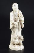 A Japanese ivory okimono of a farmer and a dog, early 20th century, the farmer holding a sprig of