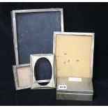 Four assorted silver photograph frames and a silver cigarette box.