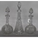 A pair of cut glass decanters & another