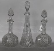 A pair of cut glass decanters & another