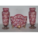 Three piece garniture of cranberry enamelled glassware