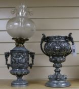 A 19th century silvered metal two handled vase and an oil lamp cast with bacchanalians, (2)
