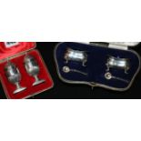 A cased pair of silver salts and a cased pair of silver pepperettes.
