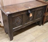 A 17th century oak coffer, with triple panel front and later carving, W.106cm