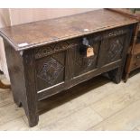 A 17th century oak coffer, with triple panel front and later carving, W.106cm