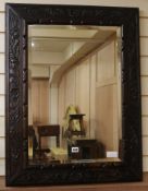An early 20th century carved oak wall mirror, with bevelled glass plate, W.67cm H.87cm