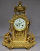 A 19th century French gilt bronze eight day mantel clock, with floral painted dial, with key and