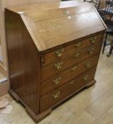 A George III oak bureau, with fitted interior and four long drawers, W.100cm