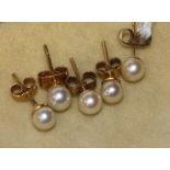 Two pairs of gold and cultured pearl ear studs and one other single ear stud.