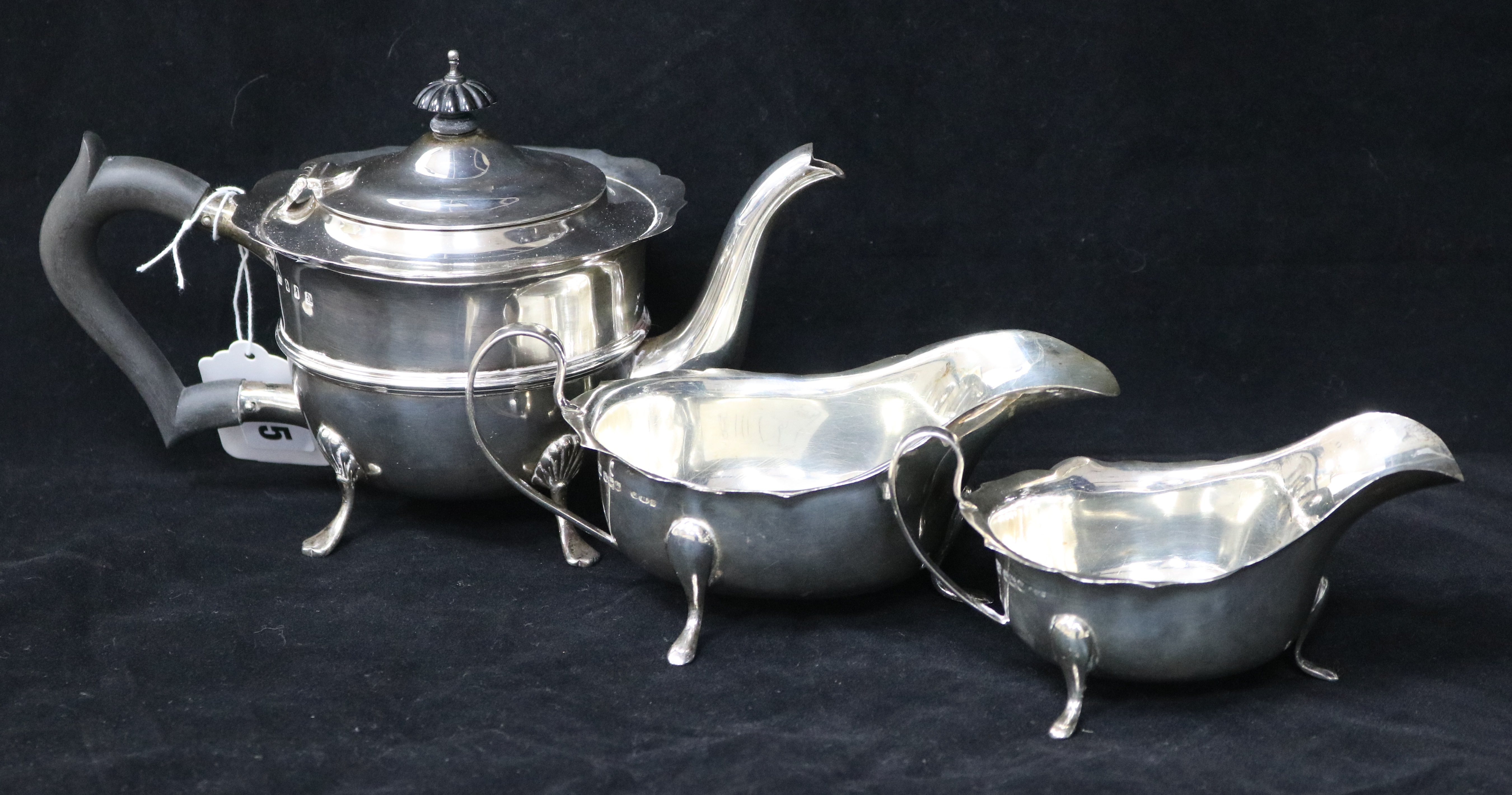 An Edwardian Irish silver teapot by Charles Lambe, Dublin 1908 and two later silver sauceboats,