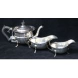 An Edwardian Irish silver teapot by Charles Lambe, Dublin 1908 and two later silver sauceboats,