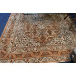 A Persian rug with heratic design on an orange and cream ground, 320cm x 210cm