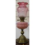 A cranberry and pink glass oil lamp and another similar