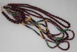 An Indian double strand facetted ruby bead necklace, a similar bracelet and a multi gem set triple