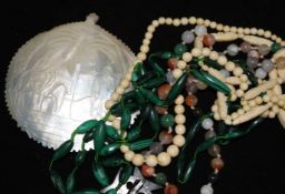 An agate bead necklace, a malachite necklace an ivory necklace a carved shell and pique cross brooch
