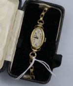 A gold wrist watch, on a rolled gold strap.