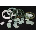 A quantity of jadeite items including bangles, a necklace and carvings.