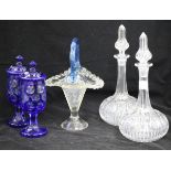 A pair of overlay lidded pots, a pair of decanters and blue handled glass basket